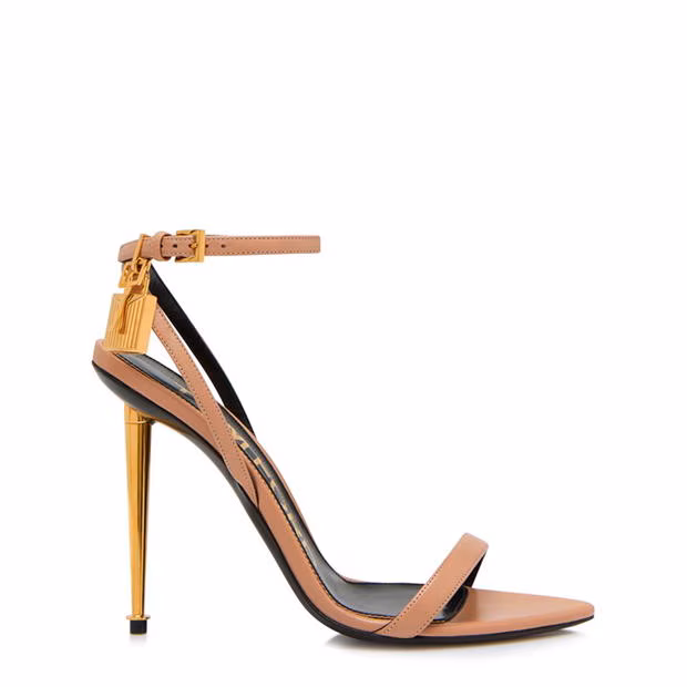 Tom Ford nude leather stiletto sandals with gold padlock and key charm at the ank