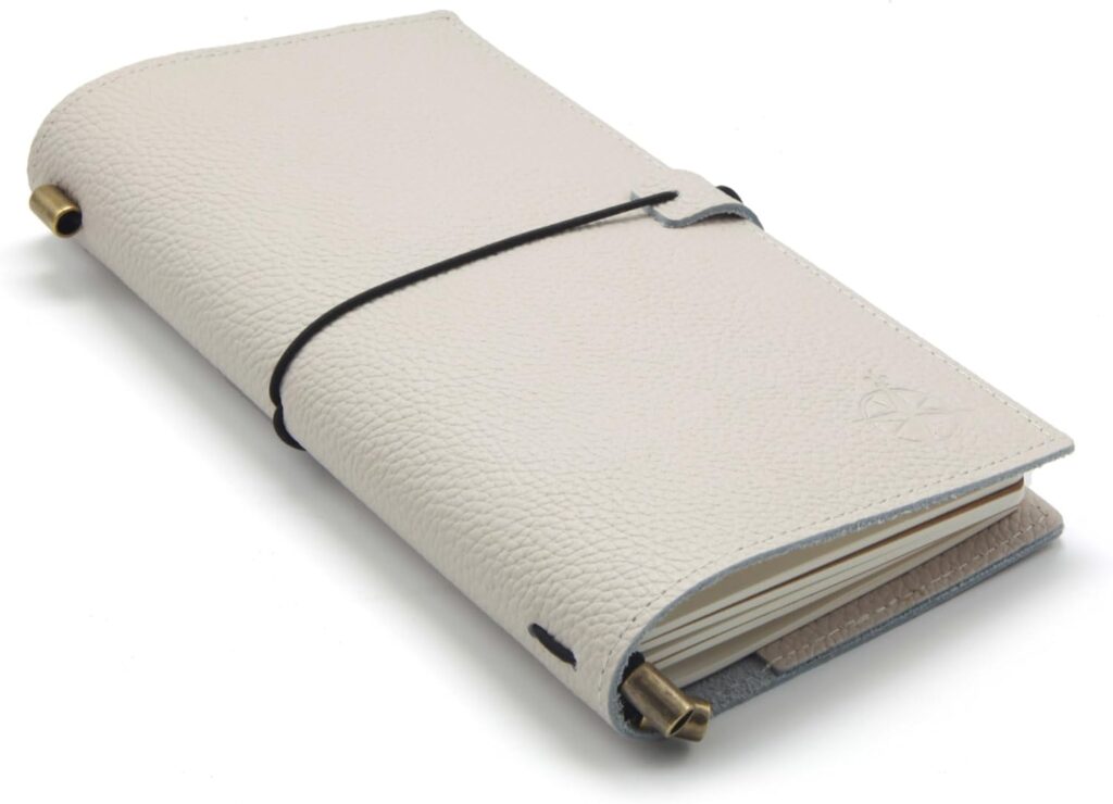 Cream leather refillable journal with pen holder and wrap closure — elegant tool for writing, planning, or reflection.