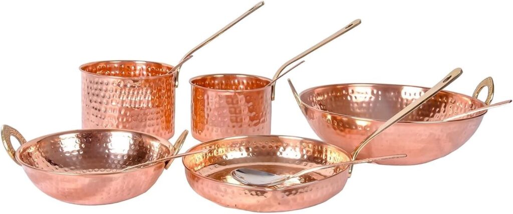 Set of five pure copper cooking pots and pans with serving spoons, displayed on white background.