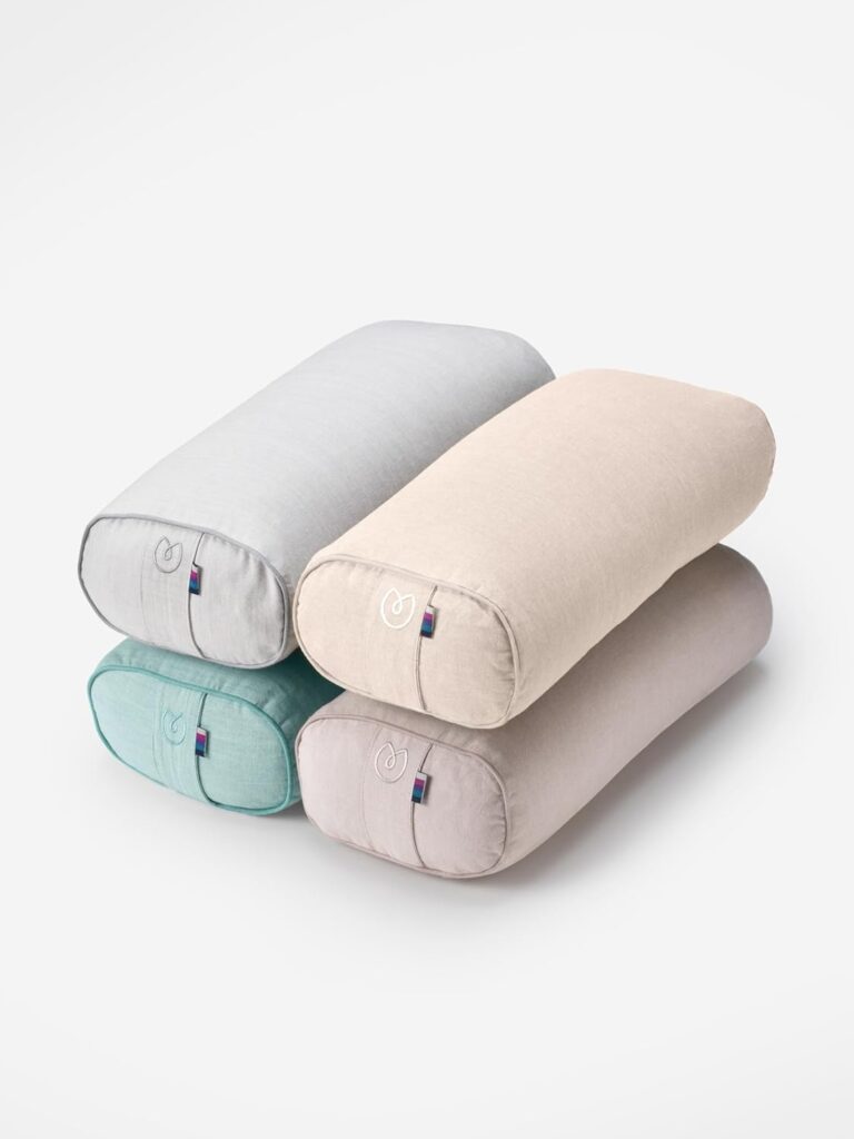 Stacked Yogamatters organic cotton yoga bolsters in soft pastel tones: grey, beige, teal, and lavender pink