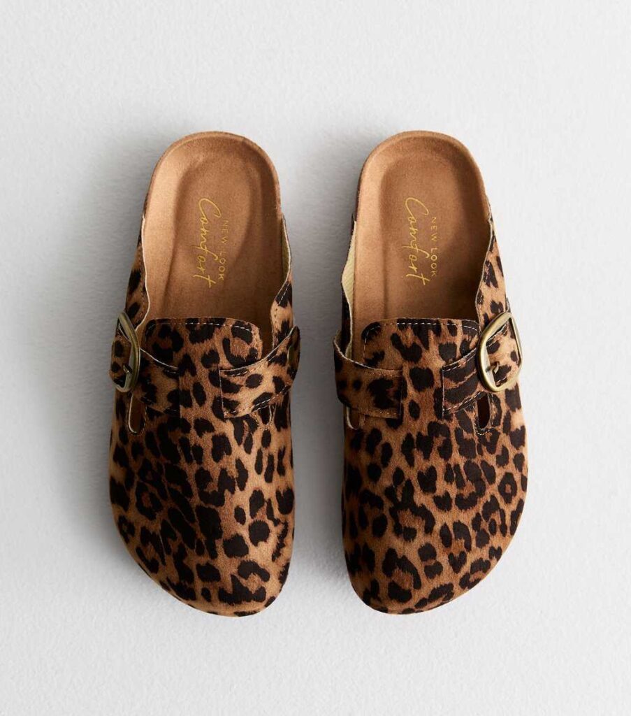 Brown animal print clogs with rounded toes and gold buckle detail, displayed on a white background.